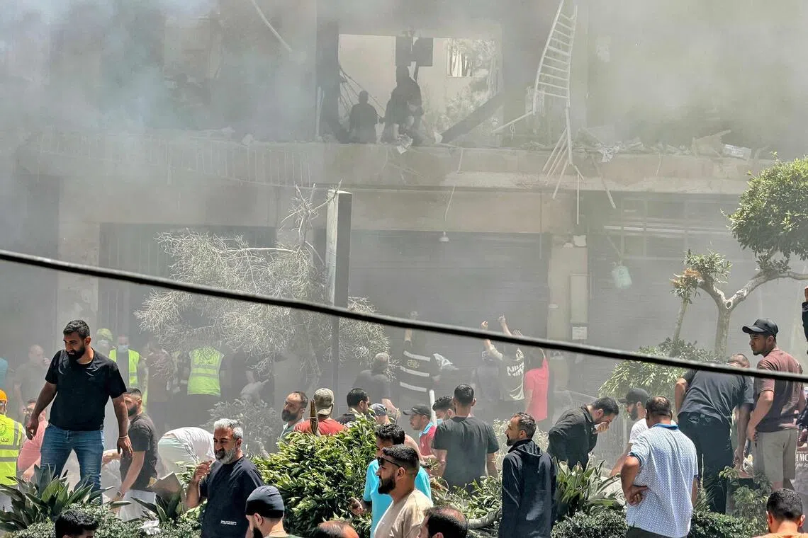 People looking for survivors at the site of an Israeli air strike that targeted a building in Beirut’s southern suburbs on June 14.