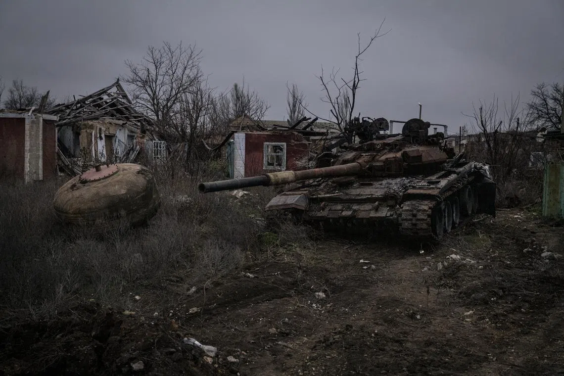 A damaged Russian tank sits near destroyed houses in the Kherson region of Ukraine.