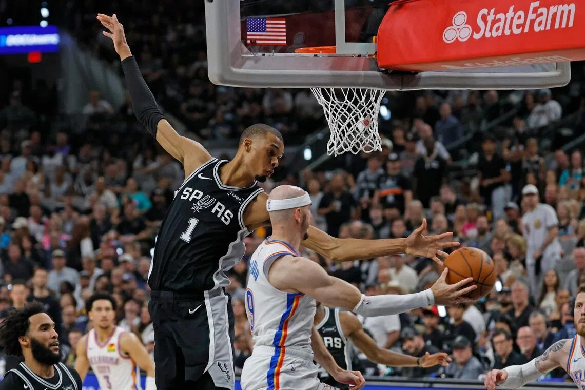 Alex Caruso of the Oklahoma City Thunder looks for a pass against Victor Wembanyama of the San Antonio Spurs in the third quarter of Game 6.