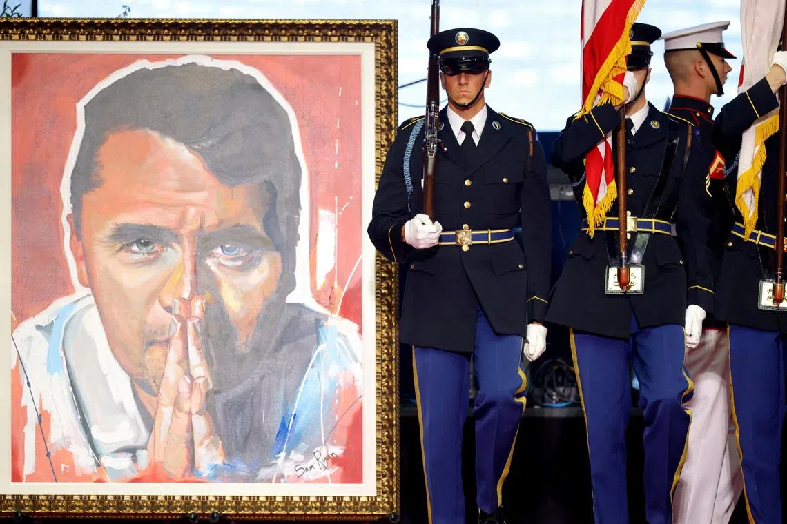 U.S. soldiers stand next to the portrait of slain conservative commentator Charlie Kirk during his memorial service at State Farm Stadium, Arizona, U.S., September 21, 2025.  REUTERS/Carlos Barria