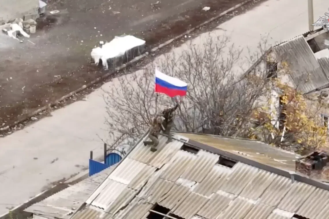 Russian soldiers set up a national flag, as the Russian Defence Ministry said its forces took control of the village of Uspenivka in Ukraine's south eastern Zaporizhzhia region, in this still image taken from video released November 7, 2025. Russian Defence Ministry/Handout via REUTERS