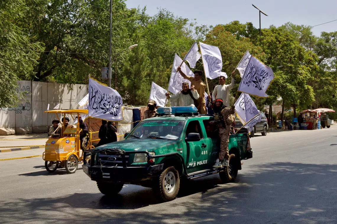 FILE PHOTO: Members of the Taliban carrying flags participate in a rally to mark the third anniversary of the fall of Kabul, in Kabul, Afghanistan, August 14, 2024. REUTERS/Sayed Hassib/File Photo