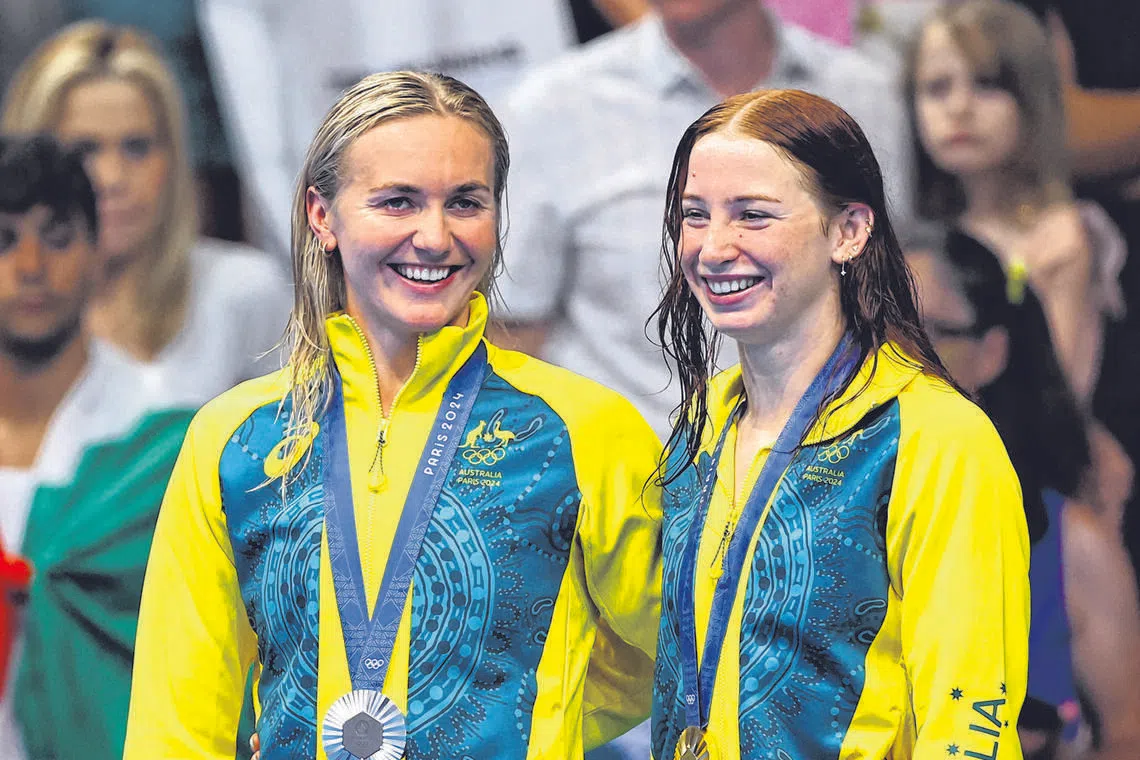 Paris 2024 Olympics - Swimming - Women's 200m Freestyle Victory Ceremony - Paris La Defense Arena, Nanterre, France - July 29, 2024. Gold medallist Mollie O'Callaghan of Australia celebrates on the podium with silver medallist Ariarne Titmus of Australia. REUTERS/Evgenia Novozhenina