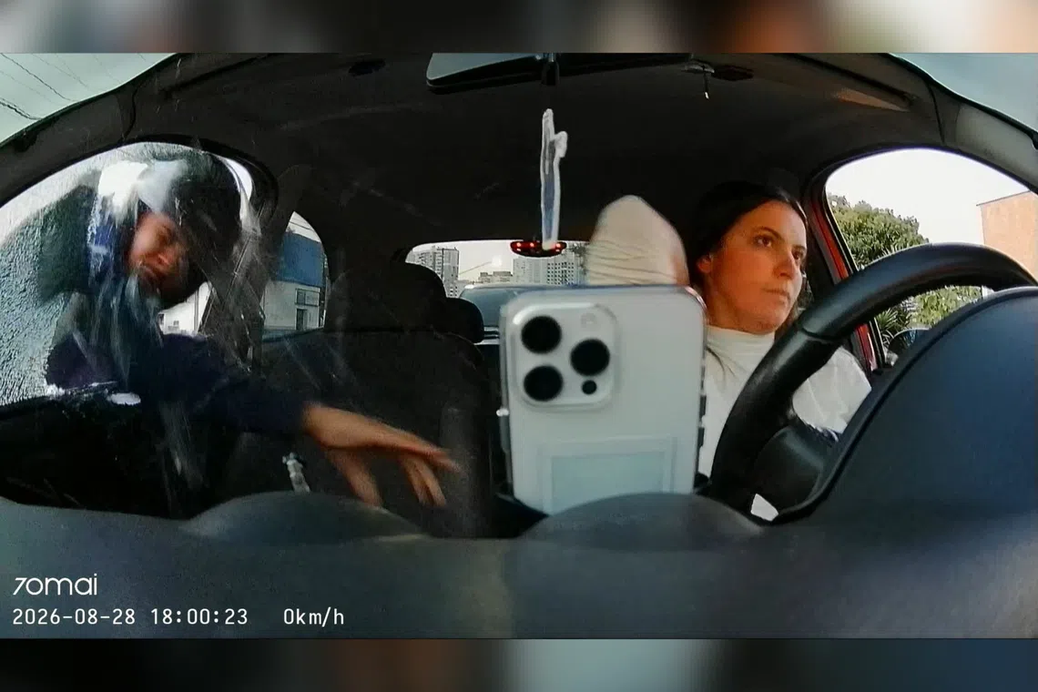 A thief breaking a car window to steal content creator Tabata Lenk’s cellphone in Sao Paulo, Brazil, on Aug 28.