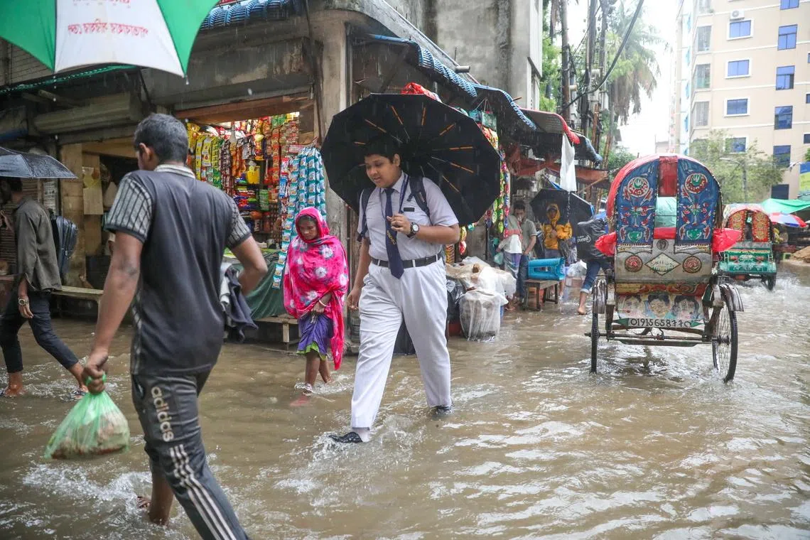 People wading along flooded streets during heavy rain in Dhaka, Bangladesh on April 29. 