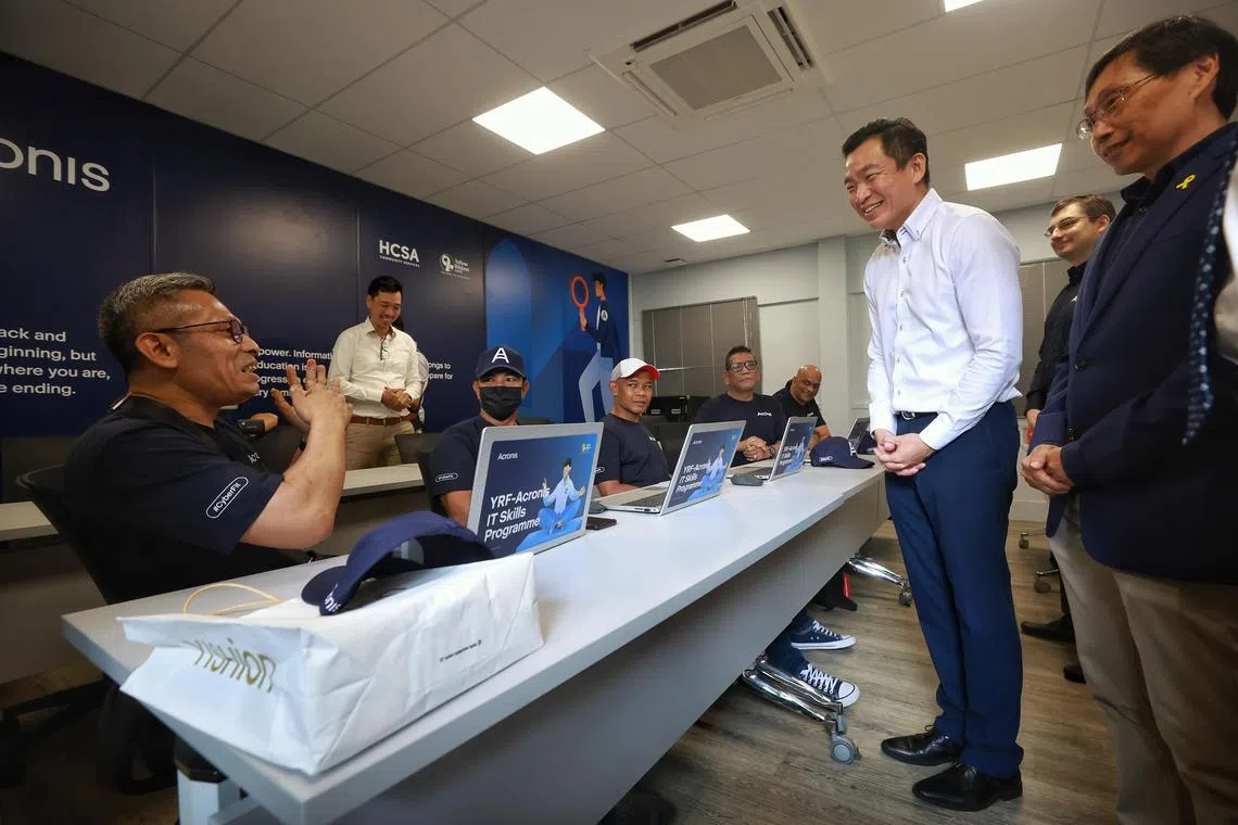 Ex-offender Hameed Maricar Bin Ahamed Maricar (left), 53-year-old self-employed batik artist, sharing with Senior Parliamentary Secretary for Culture, Community and Youth, and Social and Family Development Eric Chua how learning to create presentation slides has helped him in his work during the launch the Acronis-HCSA computer classroom at HCSA Community Services on April 17, 2023. With SPS Chua are (from right) HCSA Board of Directors vice-president Yeo Jih-Shian and Acronis Senior Vice-President Pasha Ershow. ST PHOTO: KEVIN LIM hnhcsa17