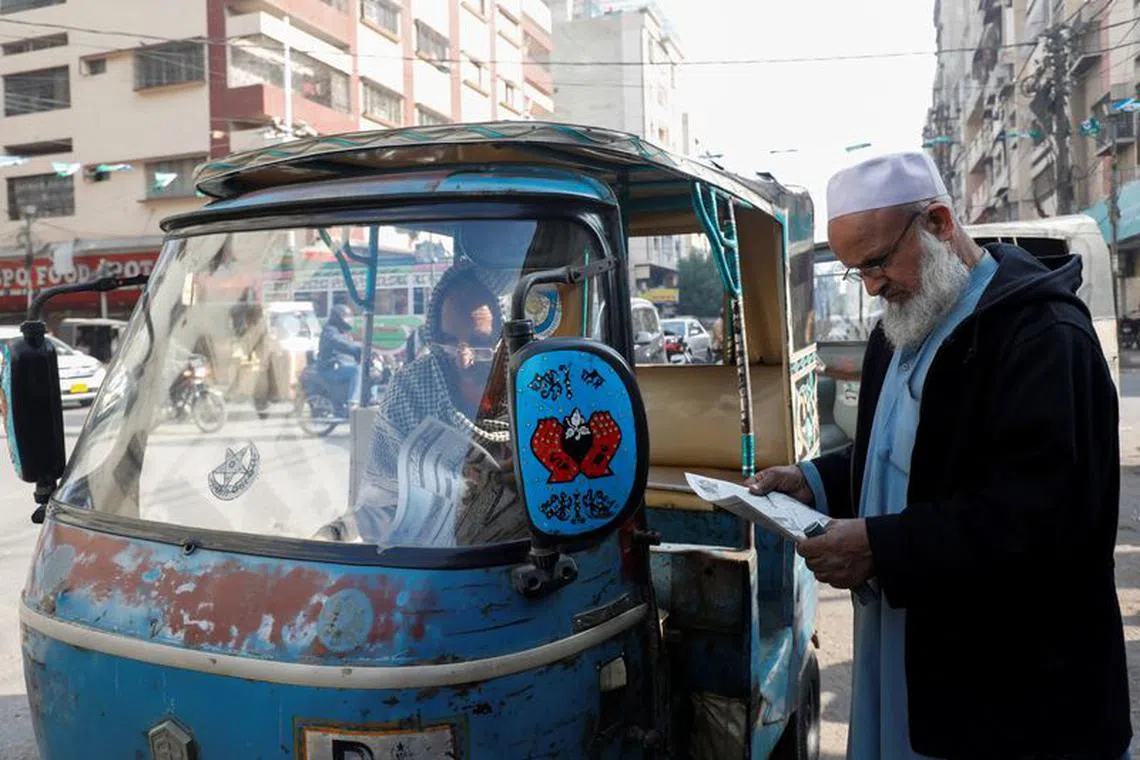 Men read newspapers, after the Pakistani foreign ministry said the country conducted strikes targeting separatist militants inside Iran, along a road in Karachi, Pakistan January 18, 2024. REUTERS/Akhtar Soomro