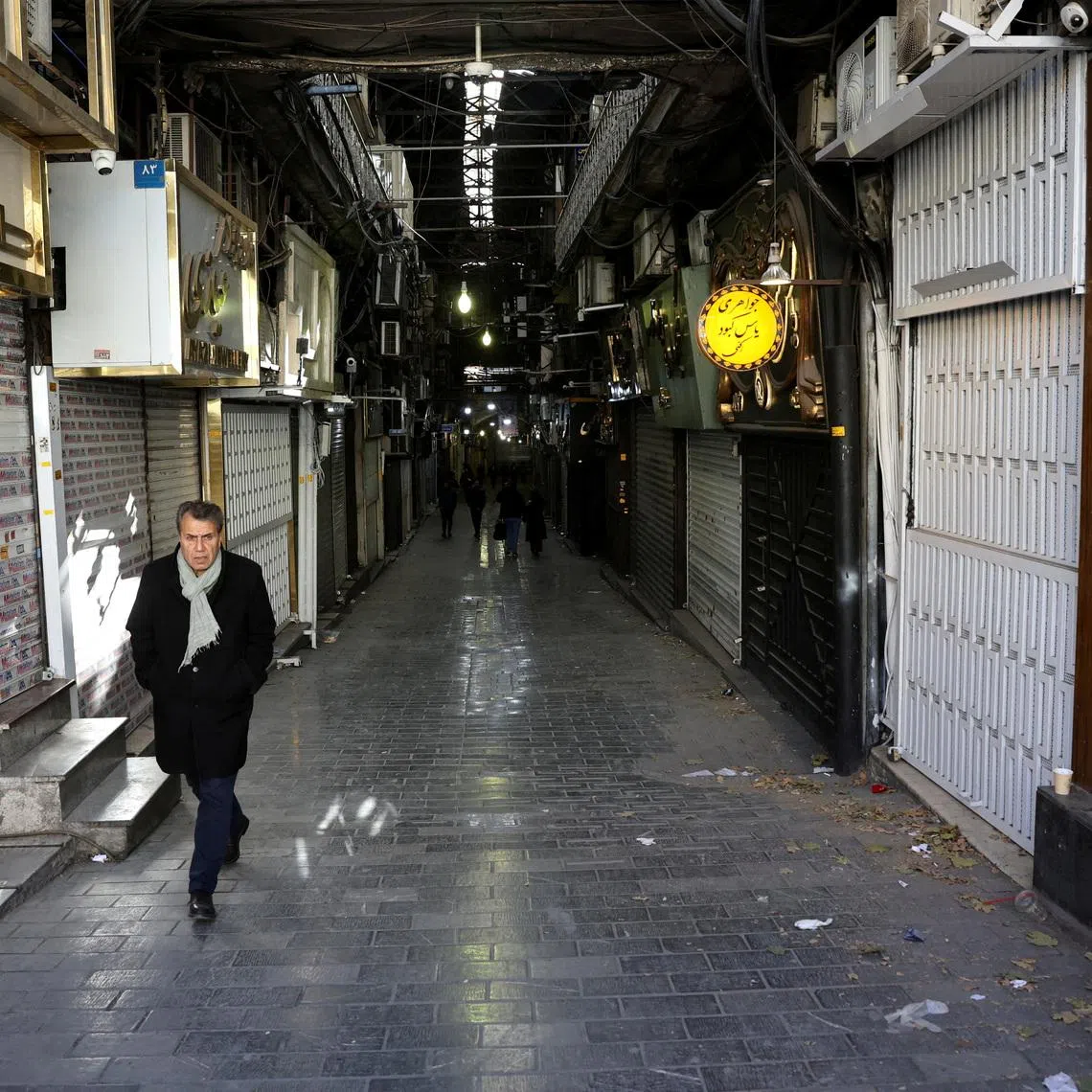 FILE PHOTO: People walk past closed shops following protests over a plunge in the currency's value, in the Tehran Grand Bazaar, Tehran, Iran, December 30, 2025. Majid Asgaripour/WANA (West Asia News Agency) via REUTERS/File Photo