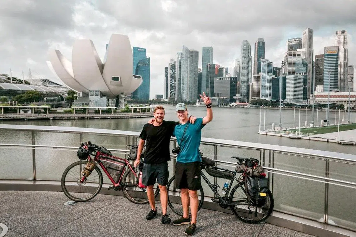 Mr Valterri Heinila (L) and Mr Alvari Poikola (R) pose for photograph after completing their 15,400 km journey from Finland to Singapore by bicycle.