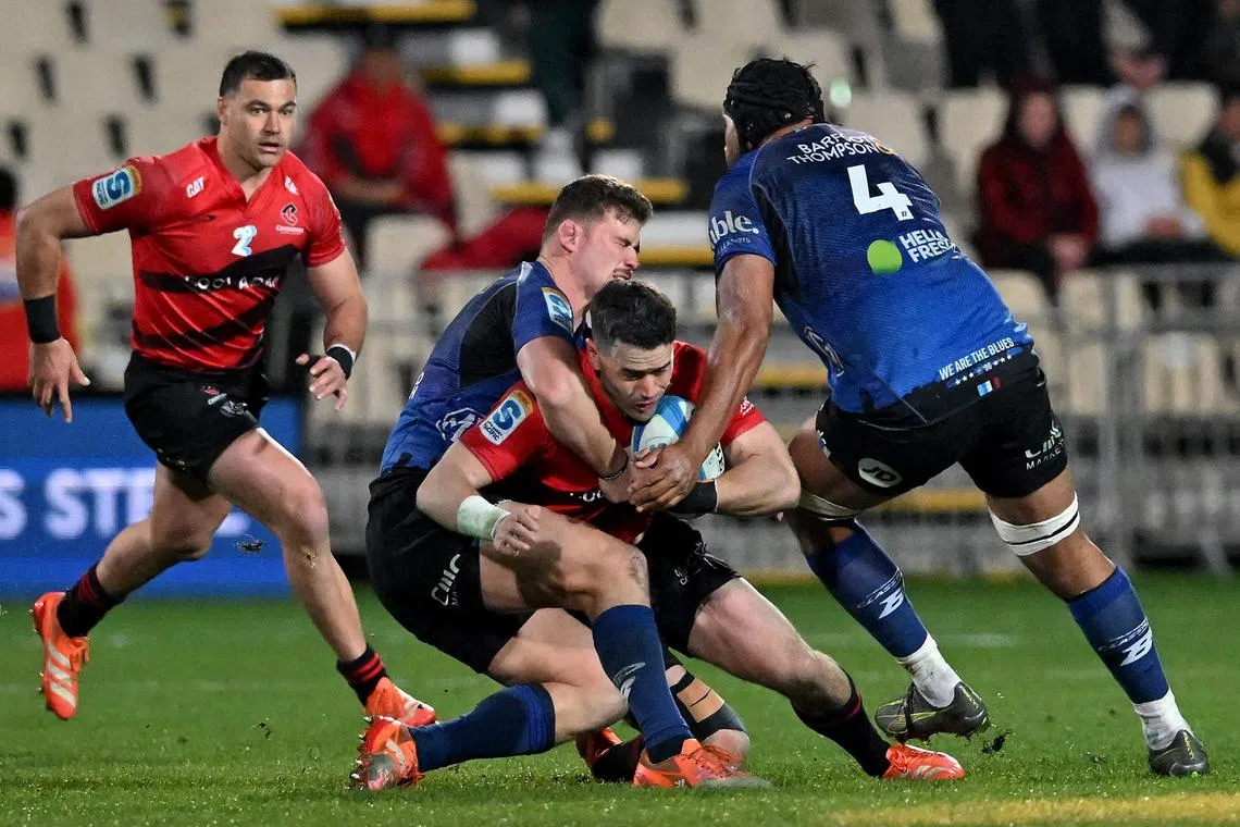 Canterbury Crusaders' Will Jordan is tackled in the Super Rugby Pacific semi-finals between fellow New Zealand team Auckland Blues in Christchurch on June 13, 2025.