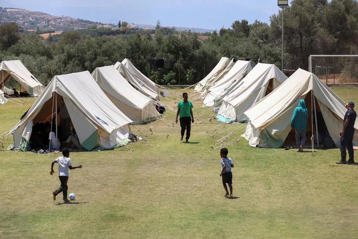 FILE PHOTO: Children play near tents as recently arrived migrants shelter at a temporary camp set up on a soccer pitch in the region of Rethymno on Crete island, Greece, June 24, 2025. REUTERS/Stefanos Rapanis/File Photo