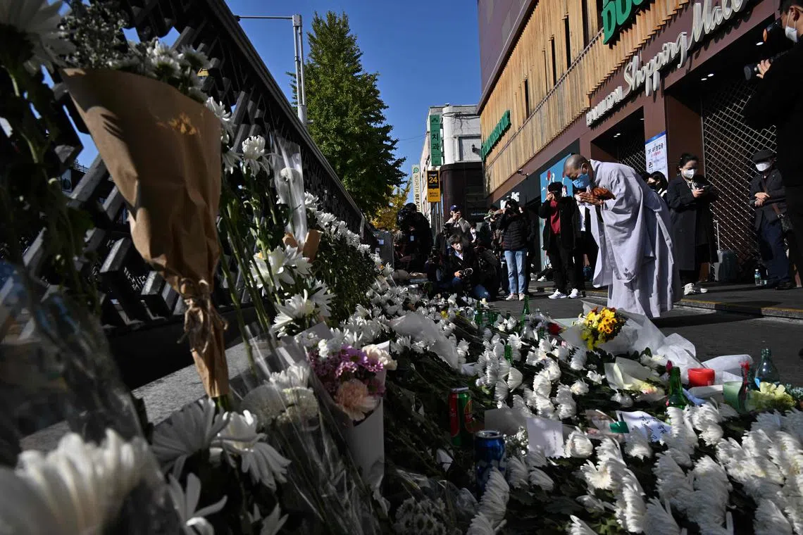 A Buddhist nun prays at a makeshift memorial outside a subway station in the district of Itaewon, Seoul on Oct 31, 2022.