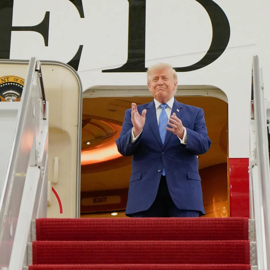 US President Donald Trump applauds as he tours the VC-25B aircraft gifted by Qatar that will be used as Air Force One, at Joint Base Andrews, Maryland, on June 19.