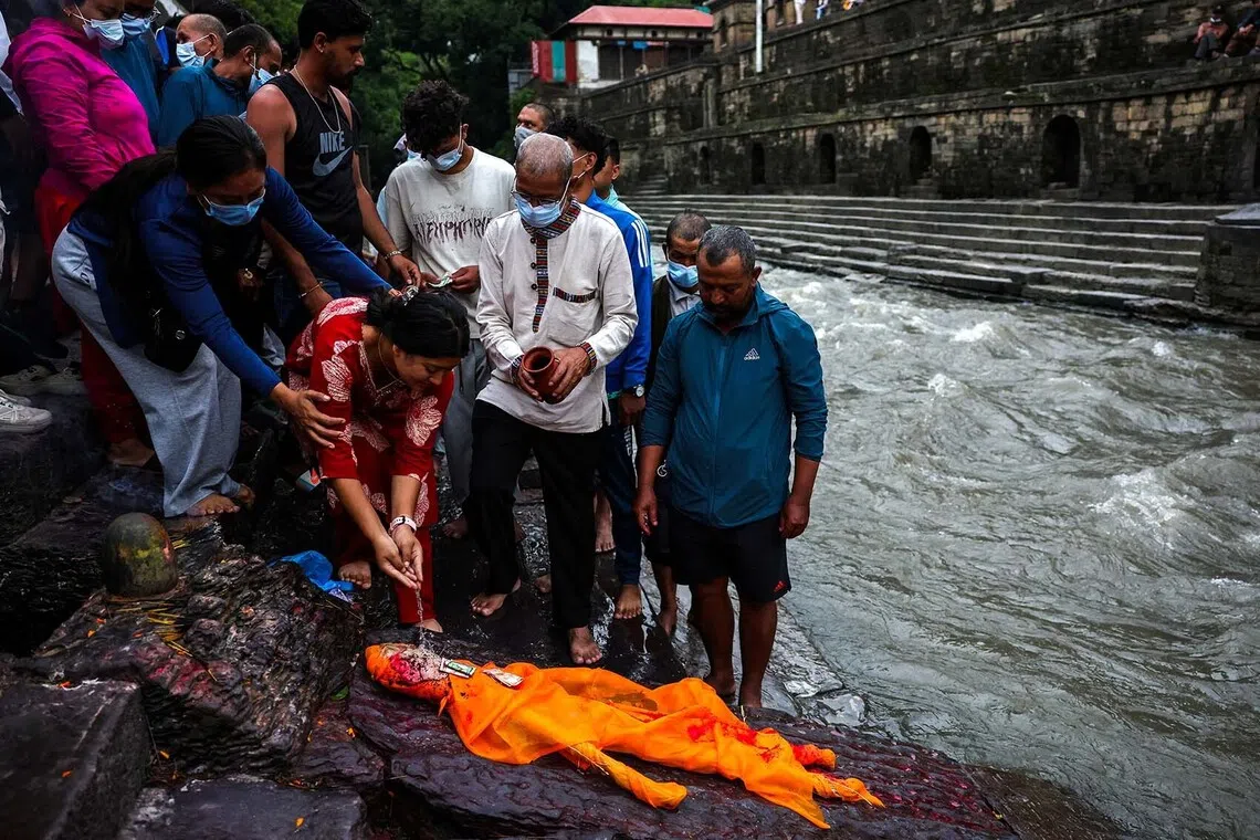 A relative of Sabin Timalsina, 21, pours water during his cremation rituals using an effigy as his body remained missing following the deadly flash floods and mudslide, on the premises of Pashupatinath Temple in Kathmandu, Nepal, September 2, 2026. REUTERS/Athit Perawongmetha TPX IMAGES OF THE DAY