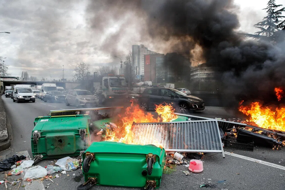 epa10527949 A barricade burns as protesters block the traffic on Paris' peripheral boulevard in the morning hours to distribute flyers against the French government's pension reform, in Paris, France, 17 March 2023. French Prime Minister Elisabeth Borne on 16 March had announced the use of article 49 paragraph 3 (49.3) of the Constitution of France to have the text on the controversial pension reform law to be definitively adopted without a vote.  EPA-EFE/TERESA SUAREZ