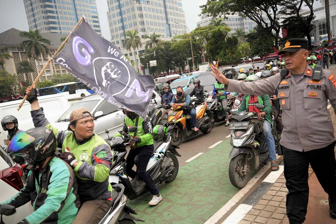 App-based motorcycle taxi drivers take part in a demonstration held as part of a strike staged to protest against what they described as an inhumane profit-sharing system, in Jakarta on August 29, 2024. (Photo by BAY ISMOYO / AFP)