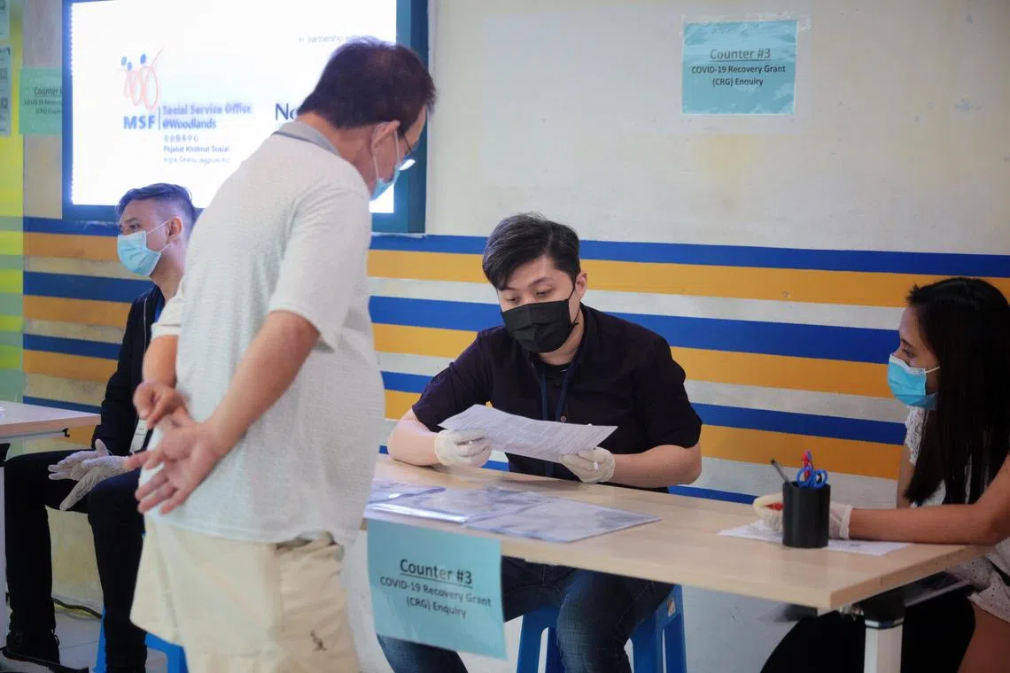 Social Service Office staff at Woodlands Civic Centre on Jan 18, 2021 attending to a man making inquiries about the Covid-19 Recovery Grant, which helps those who have been financially affected by the pandemic.