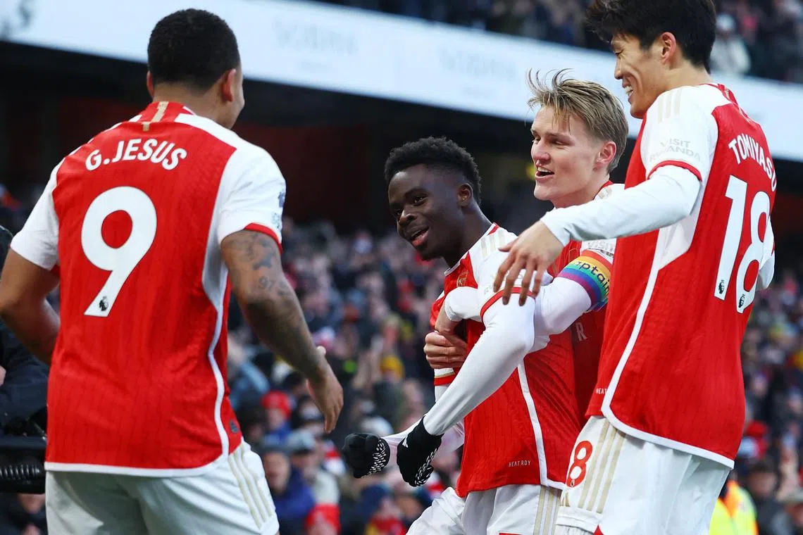 Arsenal's Bukayo Saka celebrates scoring their first goal with Martin Odegaard, Gabriel Jesus and Takehiro Tomiyasu.