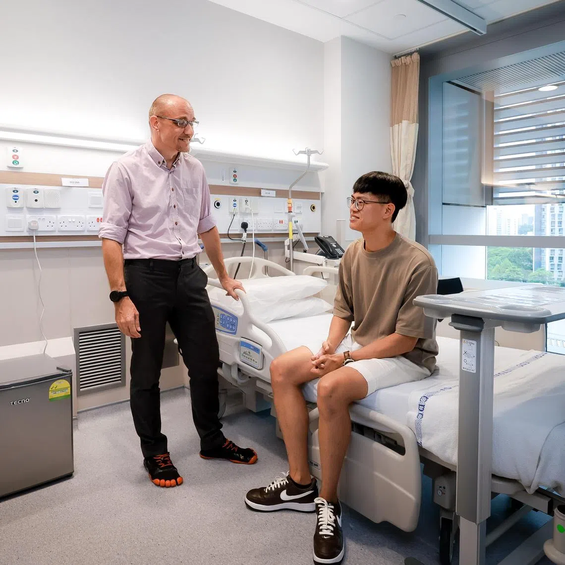 A/Prof Barnaby Young, head, Singapore Infectious Disease Clinical Research Network, and the Principal Investigator for Sing-CoV, and Goh Zhi Hao, a student and the first participant to be recruited for the human challenge study, at an NCID ward on March 12, 2025.