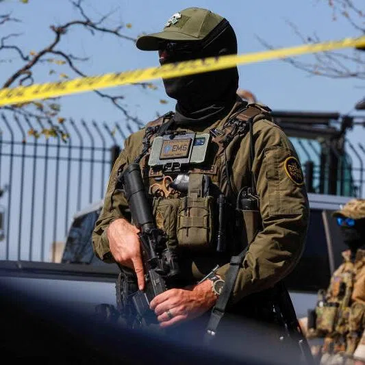 A US Border Patrol officer stands behind tape during demonstrators' standoff with US Immigration and Customs Enforcement (ICE) and federal officers in Chicago, Illinois, on Oct 4, 2025.