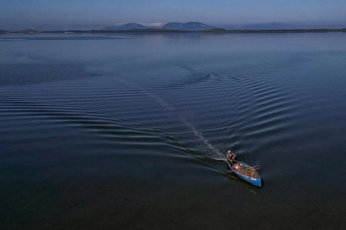 A drone view shows a fisherman sailing his boat near the Vjosa-Narta Protected Area, where a luxury resort is planned by a company linked to Donald Trump's son-in-law, Jared Kushner, in Zvernec near Vlora, Albania, June 10, 2026. REUTERS/Florion Goga