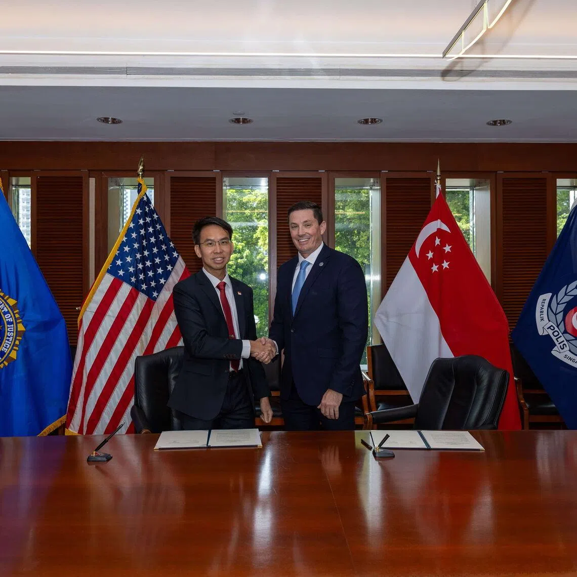 The Singapore Police Force’s deputy commissioner of investigation and intelligence Zhang Weihan (left) and the FBI’s assistant director for the Criminal Division Heith R. Janke inked the MOU in Singapore on July 24.