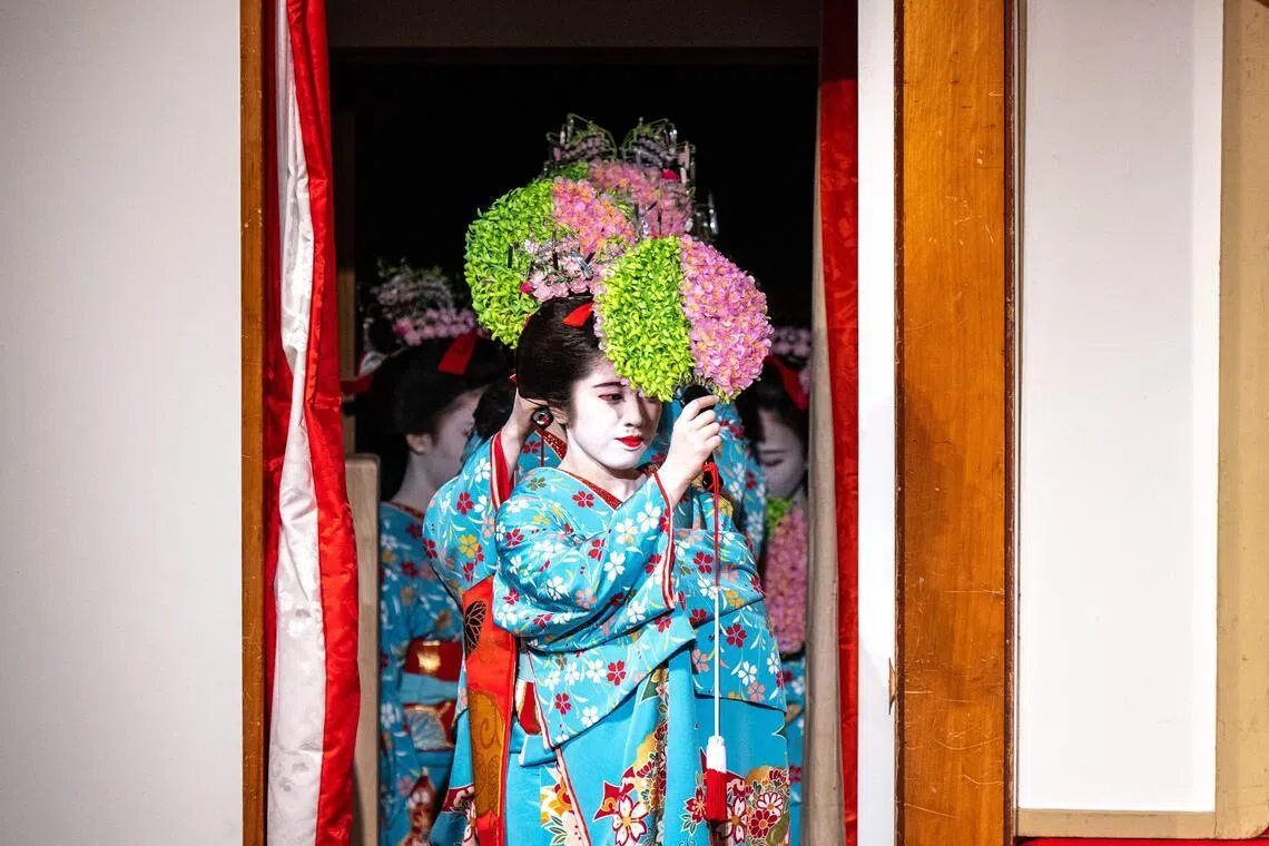 Geisha and maiko (apprentice geisha) take part in a rehearsal for the annual "Miyako Odori" -- which means "capital city dance" in Japanese, at the Gion Kobu Kaburenjo in Kyoto on March 31, 2026. Against a backdrop of blooming cherry blossoms, a group of geishas elegantly shuffle onto a stage in Japan's Kyoto city to begin a centuries-old performance celebrating the arrival of spring.
Dressed in sky blue kimonos emblazoned with flowers, the dancers twist and twirl in unison in front of hundreds of spectators eager to see the annual "Miyako Odori" in the nation's spectacular ancient capital. (Photo by Philip FONG / AFP)