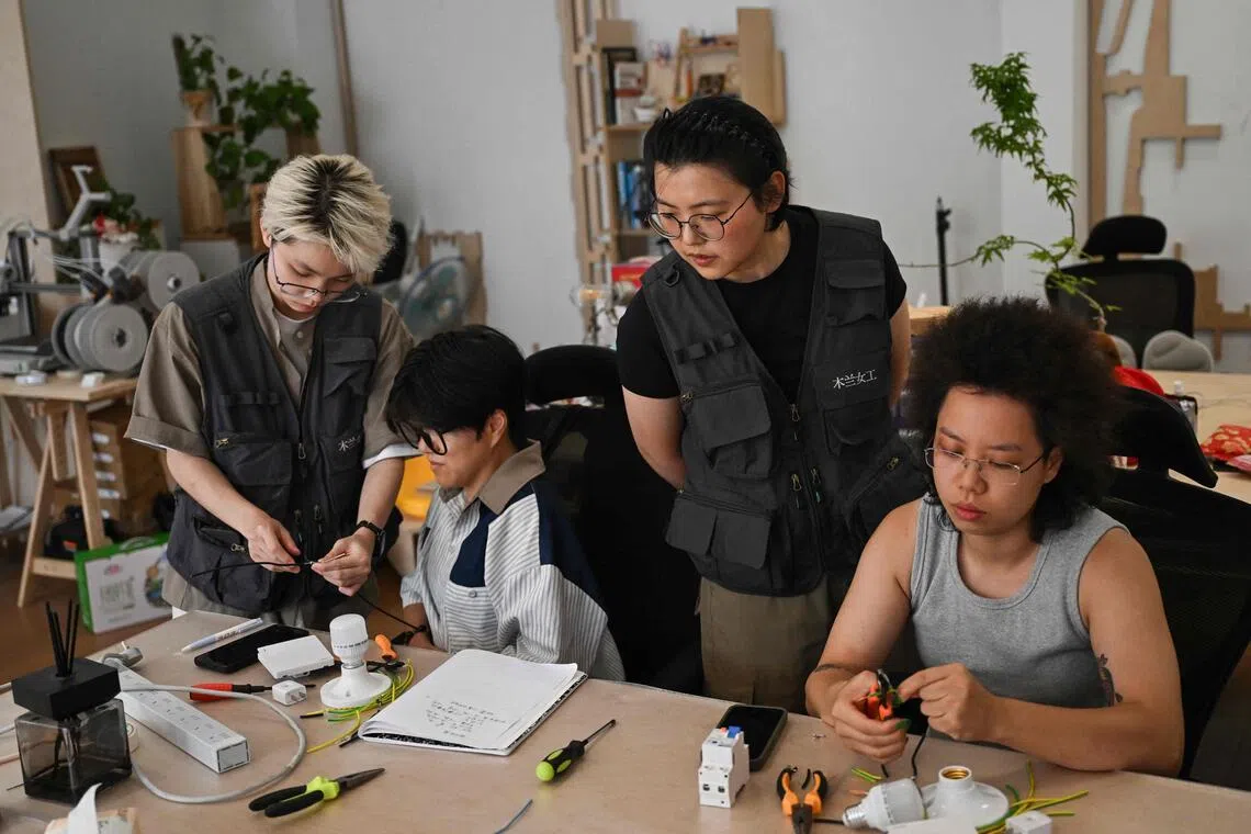 Instructors Wu Shuang (second from right) and Wang Risun (left) giving an electricity course to a group of women at the Mulan Build workshop in Hangzhou, China, on June 28.
