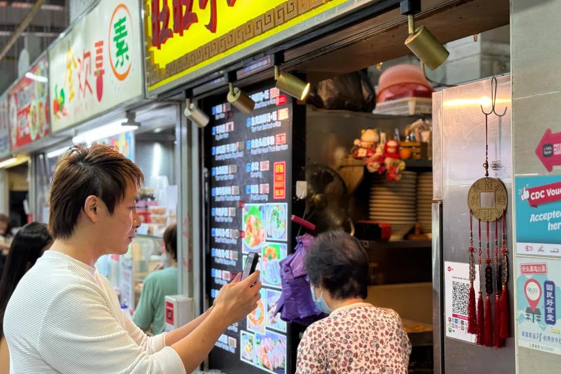 A customer uses PayLah! to scan and pay for his meal at a hawker stall. 