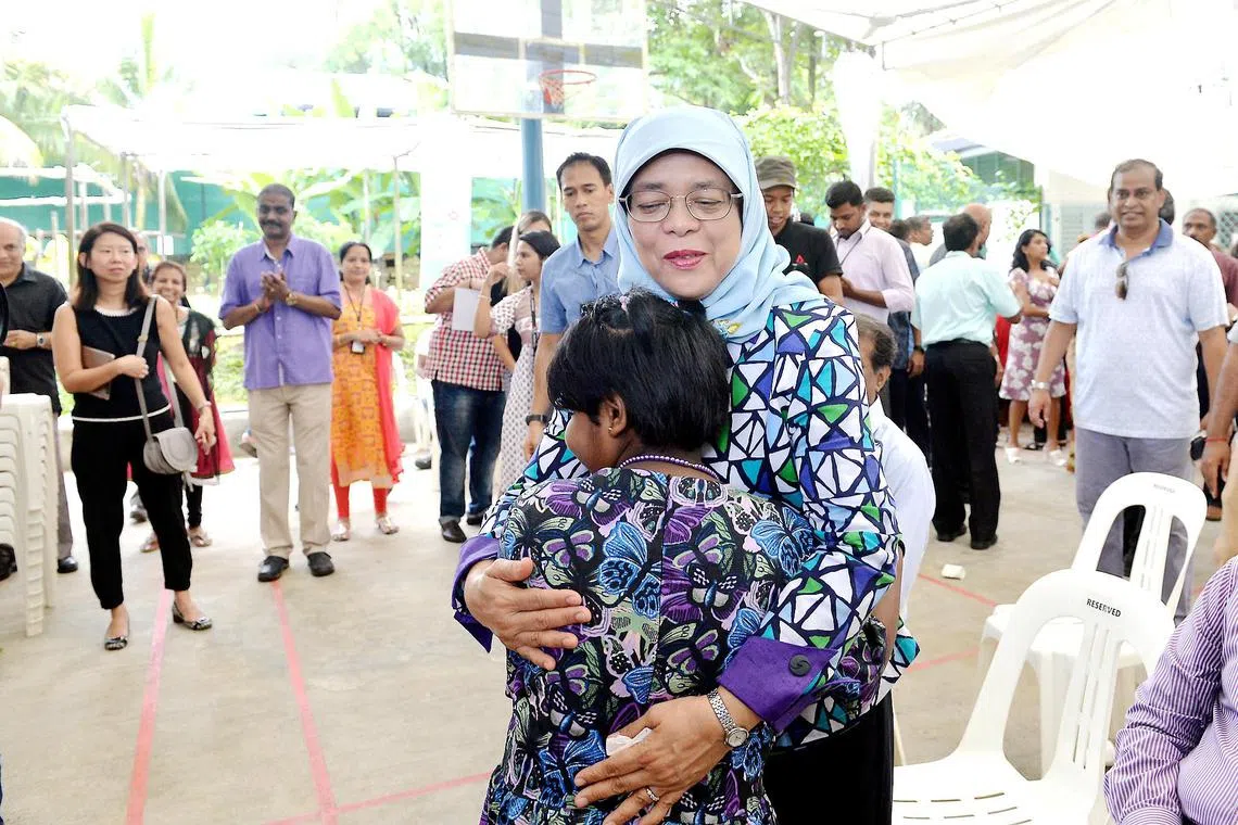 President Halimah sharing a warm hug with a child at the HEB-Ashram Halfway House’s Back-to-School event, a little over two months after she was sworn in.