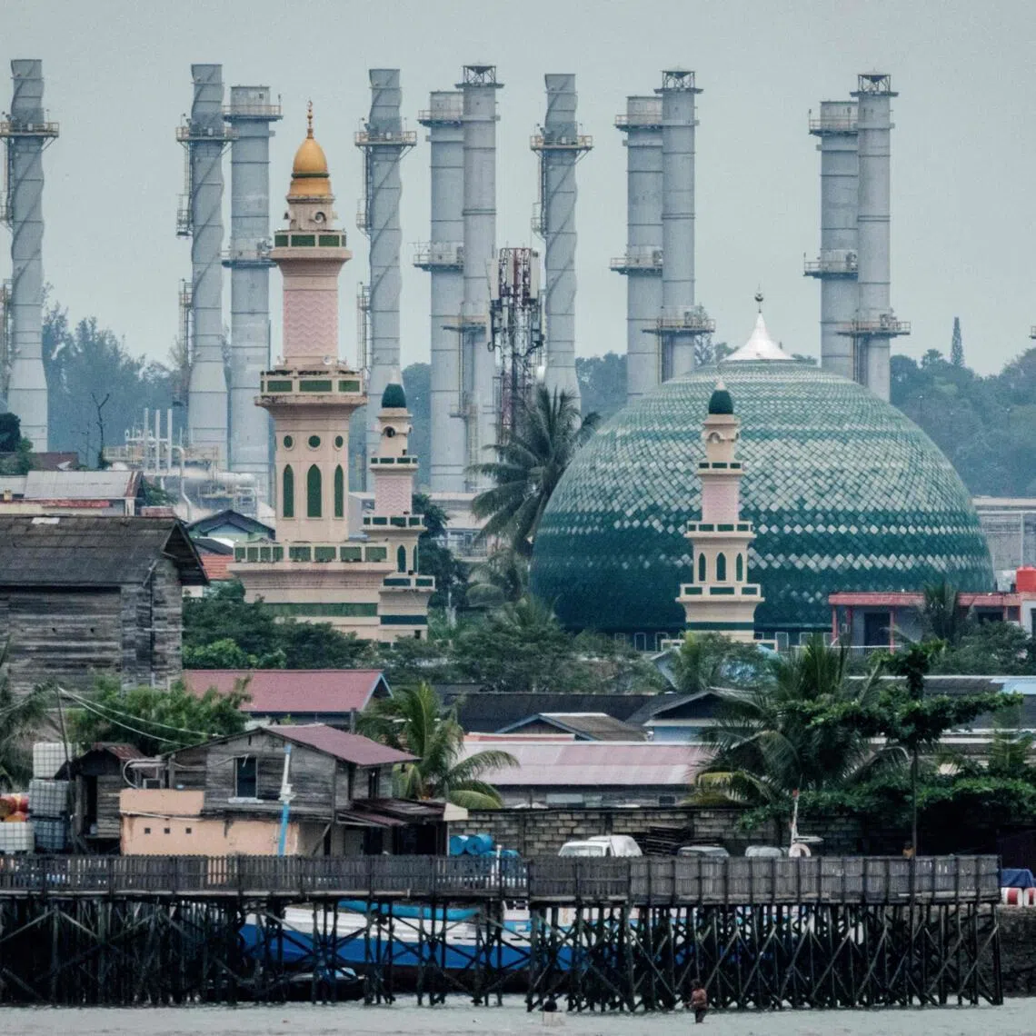 An oil refinery is seen behind a mosque in Balikpapan, Indonesia, on July 9, 2024. The country is mulling fuel-saving measures as the Middle East conflict has sent global oil prices soaring.