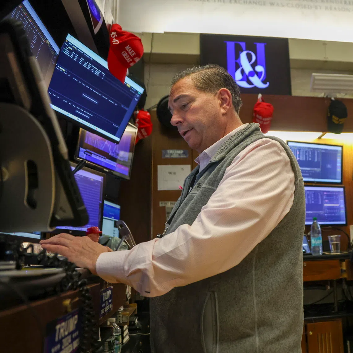 Traders work on the floor of the New York Stock Exchange before the closing bell in New York City on Oct 16.