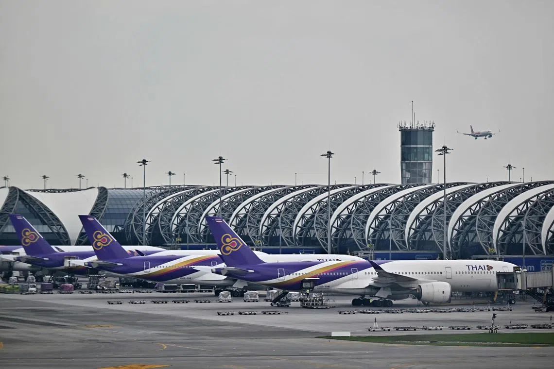 Thai Airways fleet are docked at the main terminal from inside the new SAT-1 terminal at Suvarnabhumi International Airport in Bangkok on September 25, 2023. (Photo by Lillian SUWANRUMPHA / AFP)