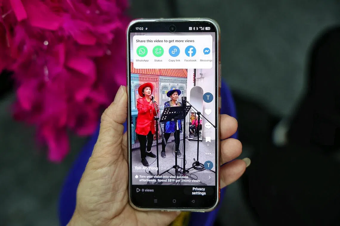 Boon Lay resident Toh Ah Yong, 73, watching the TikTok video of her performance on her mobile device.