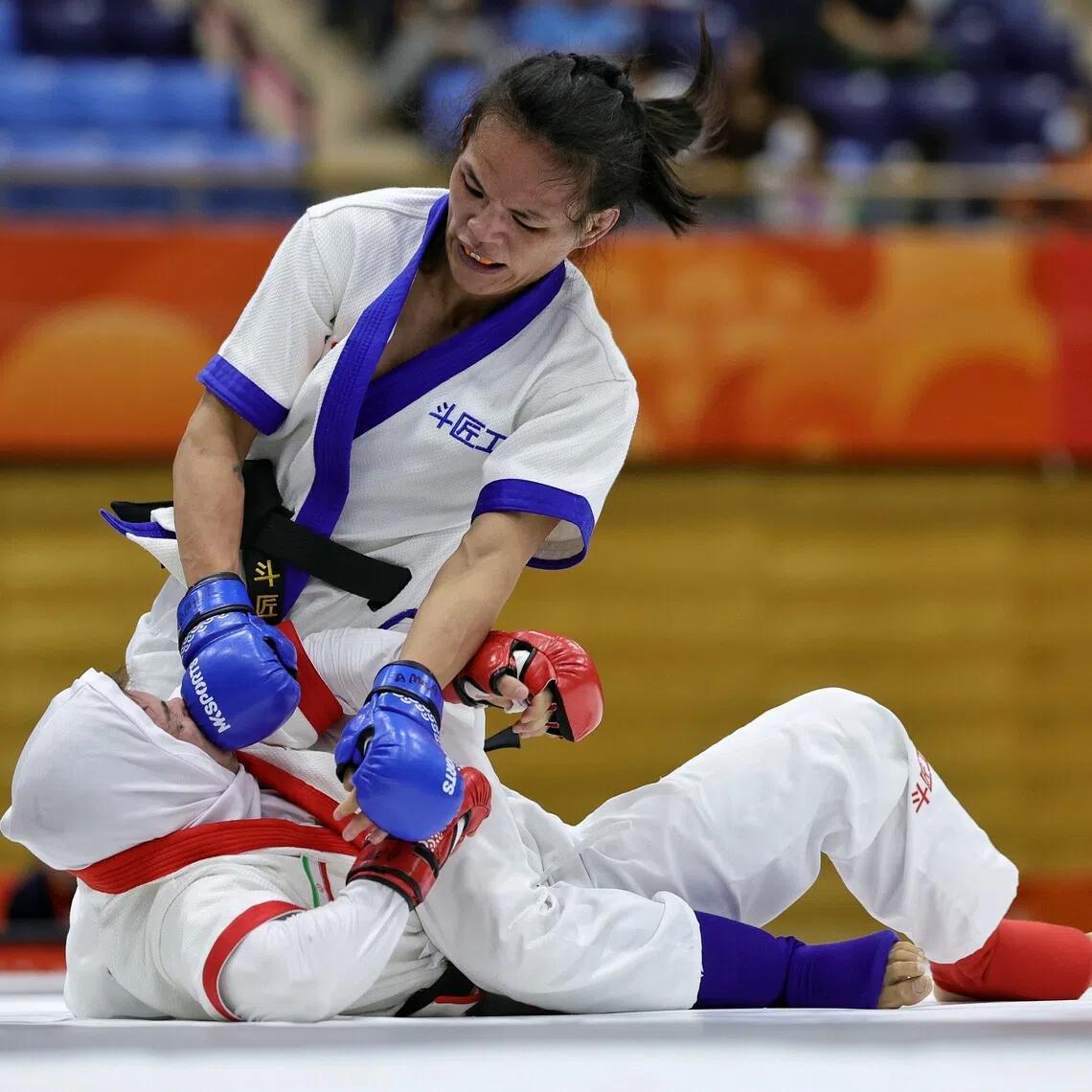 Tiffany Teo of Singapore delivering a flurry of headshots to Arezou Salimighalehtaki of Iran during the mixed martial arts women’s tradition (60kg) quarterfinal of the Aichi-Nagoya 2026 Asian Games at the Nagoya City Inae Sports Centre in Nagoya, Japan on Sept 20.