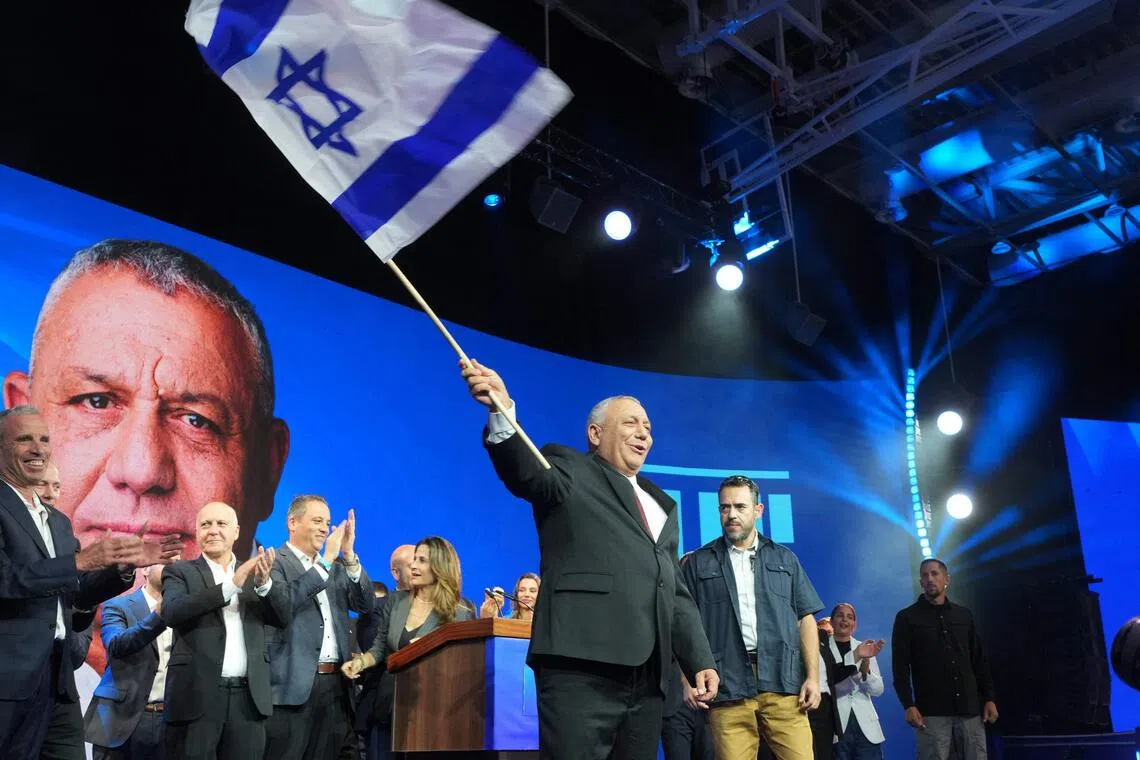 Yashar party leader Gadi Eisenkot waves Israel’s national flag at the election night rally after the first exit polls were announced, in Tel Aviv, on Oct 28.