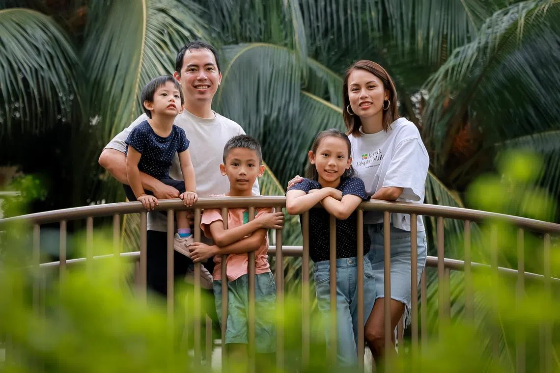 Candace Zhou and her husband Matthew Siew, with their children Eva (dark blue), 8, Noah (pink), 7, and Matilda (being carried),  3, at a playground near their home in Clementi West, Sep 16, 2023.
