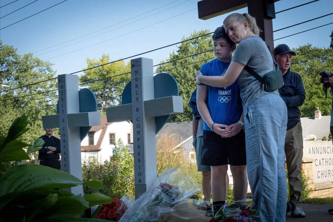 People visiting a memorial to victims of the Annunciation Catholic Church shooting in Minneapolis, on Aug 28.