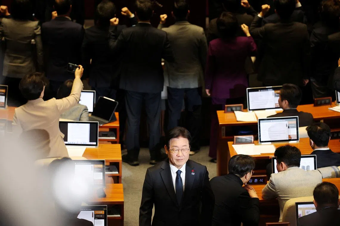 FILE PHOTO: South Korea's opposition Democratic Party leader Lee Jae-myung walks past People Power Party lawmakers protesting against National Assembly Speaker Woo Won-shik during the impeachment vote of a plenary session for South Korean acting President and Prime Minister Han Duck-sooat the National Assembly in Seoul, South Korea, December 27, 2024.   REUTERS/Kim Hong-Ji/File Photo