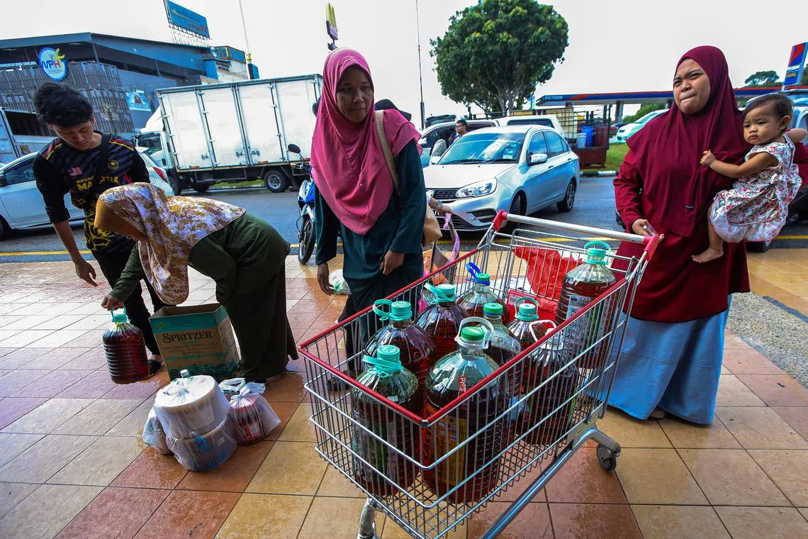 Members of the public delivering their used cooking oil to Evergreen Oil and Feed joint collection drive with the Melaka City Council. 