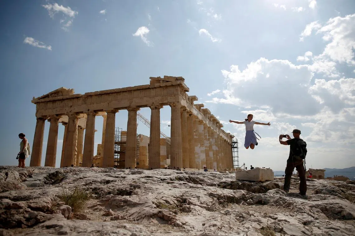 FILE PHOTO: Tourists take a picture in front of the temple of the Parthenon atop the Acropolis in Athens, Greece July 20, 2018. REUTERS/Costas Baltas/File Photo