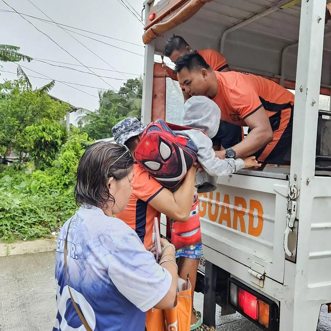 Coast guard personnel help evacuate residents of Guiuan town in central Philippines, as Typhoon Kalmaegi approaches with 120kmh winds. 
