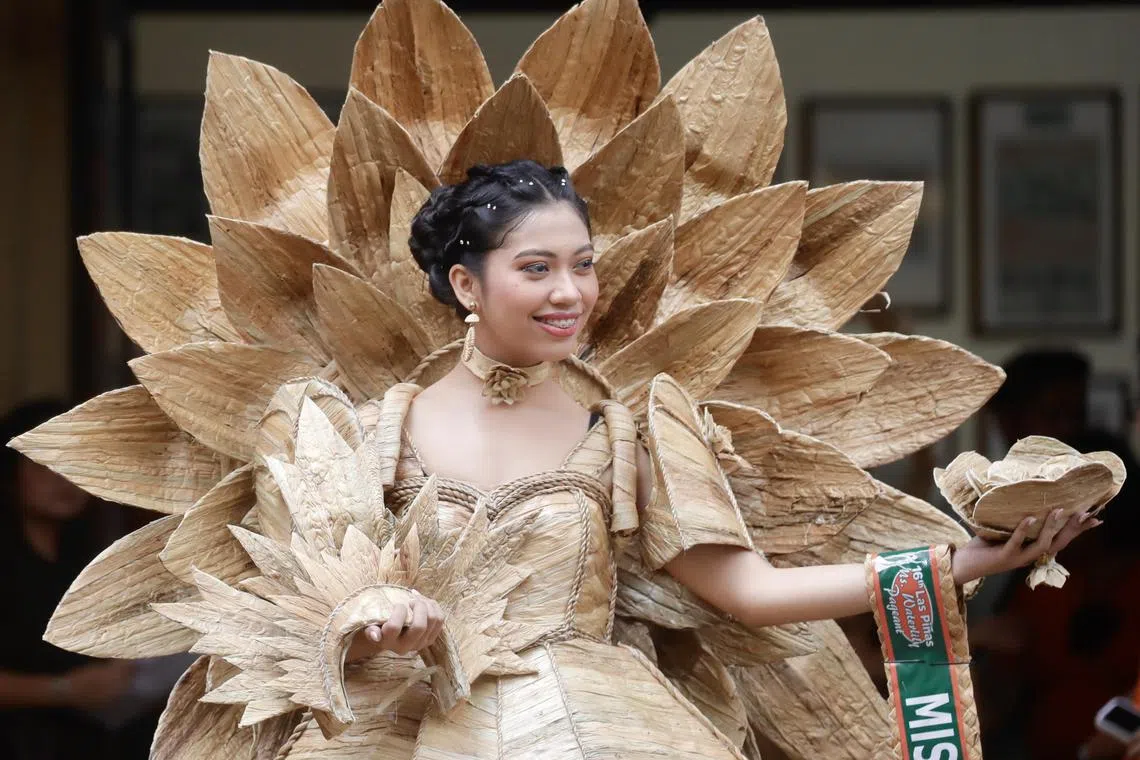 A Filipino woman wearing a gown made from dried water hyacinth stalks, poses during the Water Lily Festival in Las Pinas city, Metro Manila, Philippines on July 21, 2023. The Water Lily festival aims to promote the water hyacinth-based livelihood enterprises for residents in flood prone communities of Las Pinas city and adjacent cities.  