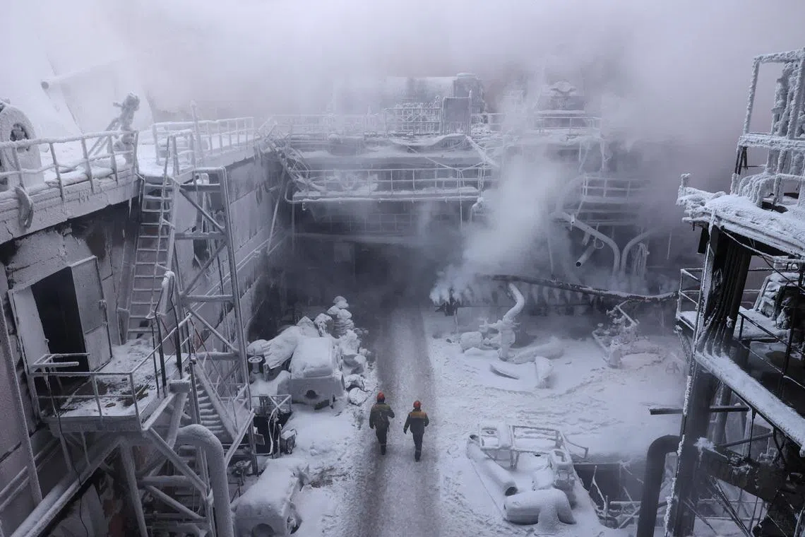 Employees walking in the compound of a thermal power plant damaged by multiple Russian missile strikes, amid Russia's attack on Ukraine, in an undisclosed location in Ukraine on Jan 21, 2026. 
