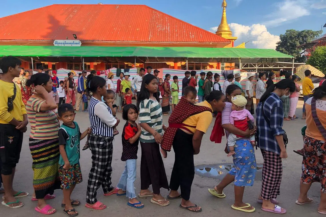 People queue for food at a monastery-turned-temporary shelter for internally displaced people (IDP) in Lashio, Shan state on November 15, 2023. Fighting has raged across Myanmar's northern Shan state for more than two weeks after an alliance of ethnic minority groups launched a surprise offensive against the military. (Photo by STRINGER / AFP)