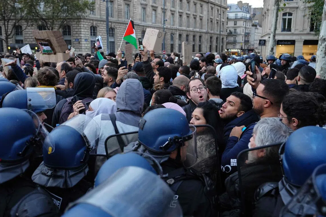 Riot police push back protesters in Paris, during a demonstration in support of Palestinians.