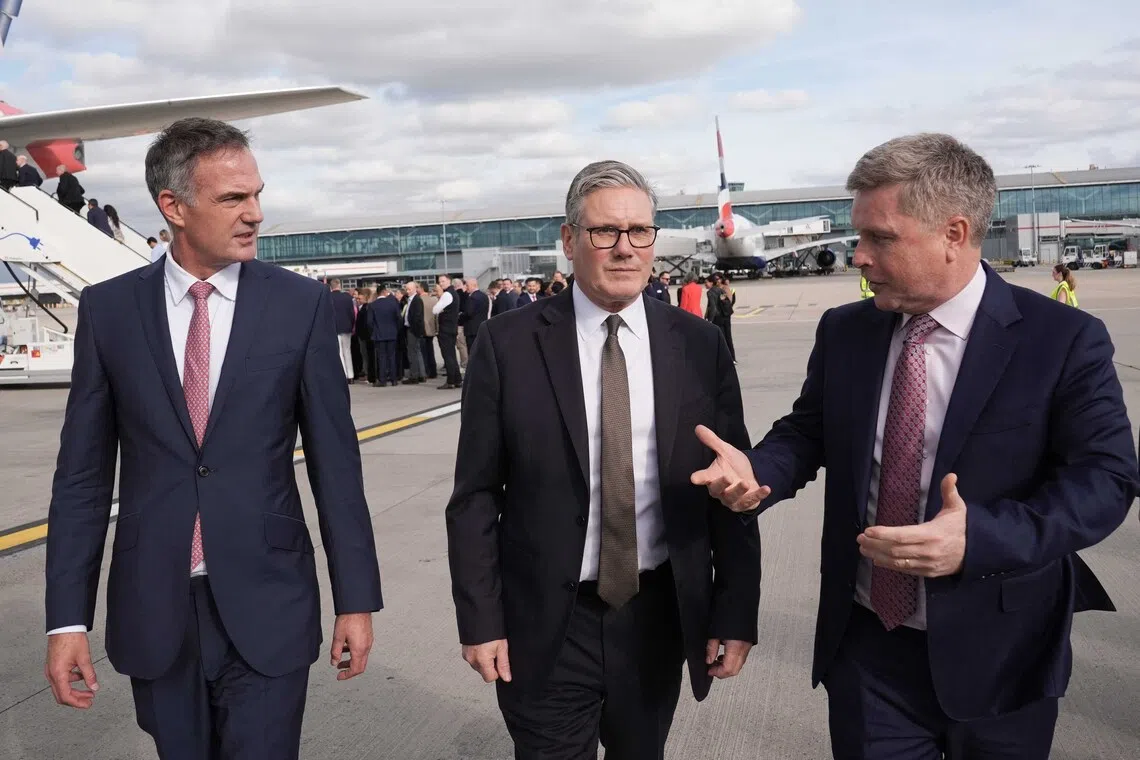 Britain's Prime Minister Keir Starmer (centre) at London's Heathrow Airport on Oct 7, before departing for a visit to India.
