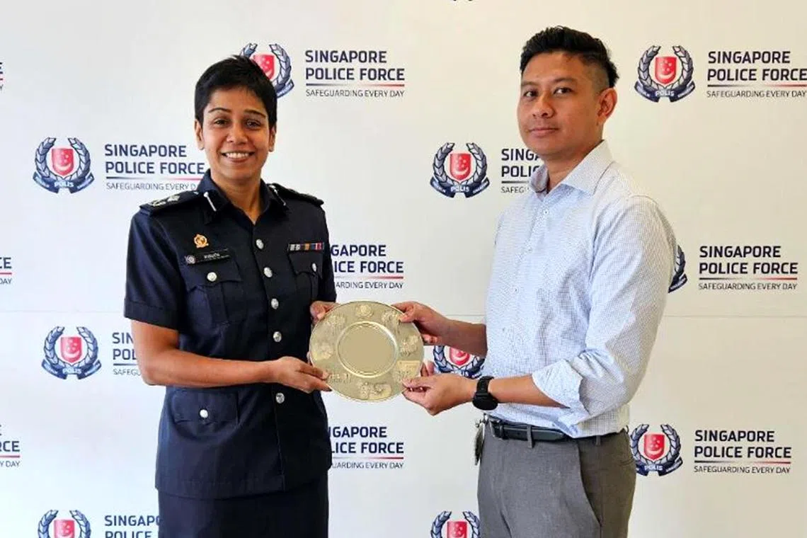 Commander Airport Police Division, Assistant Commissioner of Police
M Malathi, presenting the Public Spiritedness Award to Mr Helmi Bin Ali.