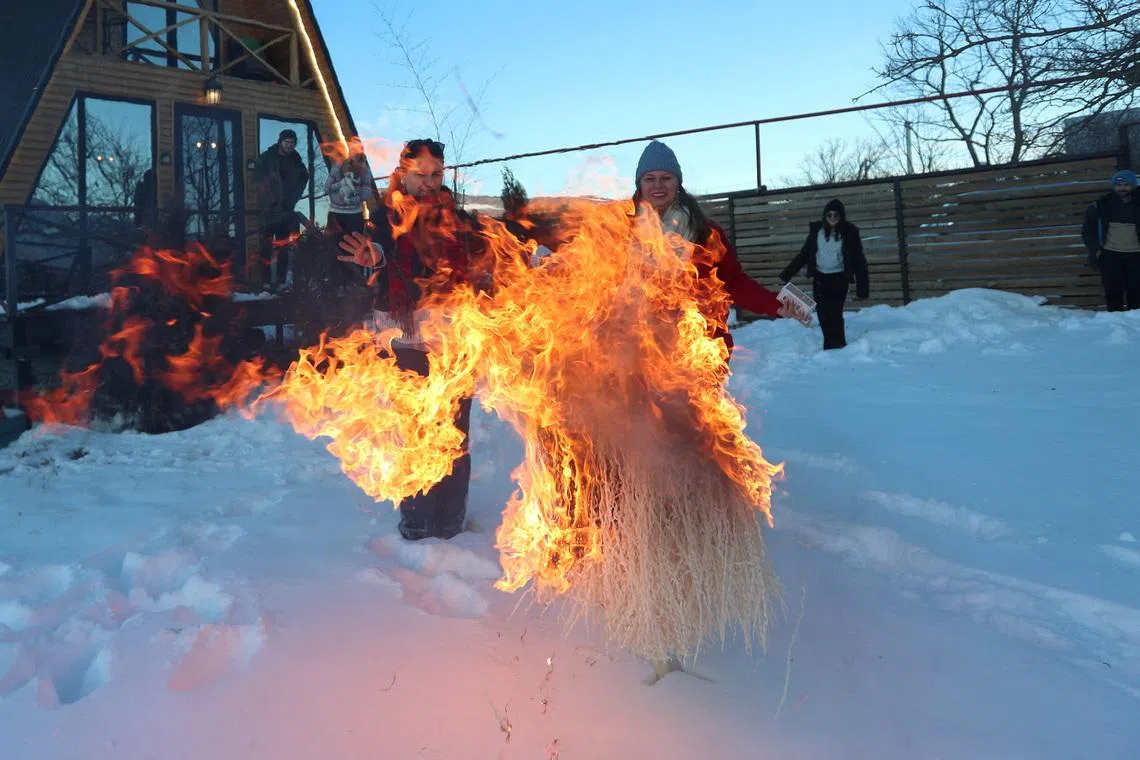 People watch the burning of chichilaki - a traditional Georgian Christmas tree made from dried walnut branches, during a celebration in the village of Tezeri, Georgia, January 3, 2026. REUTERS/Irakli Gedenidze