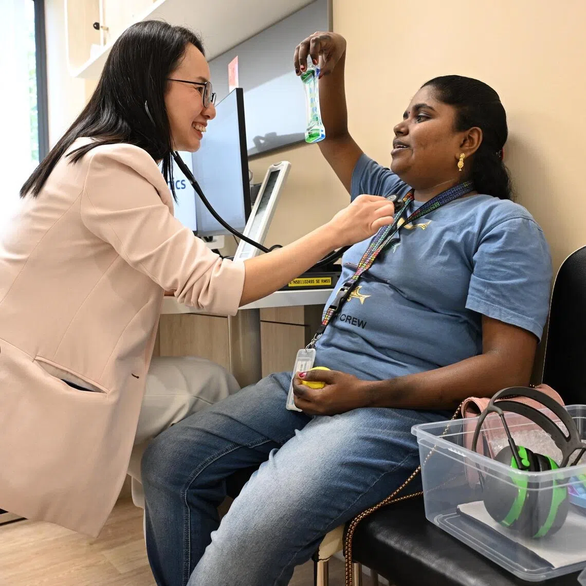 Dominique Phang and her patient Archanaa, who has autism and intellectual disability. She interacts with items from a sensory kit during a consultation session at Ang Mo Kio polyclinic.